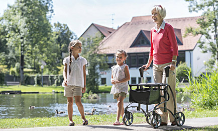 grandmother with 2 young girls walking with her walker, this describes our blog post about aging
